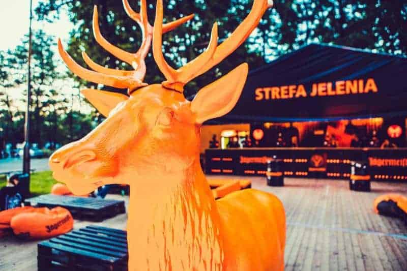 Orange deer statue in front of a bar with the sign 