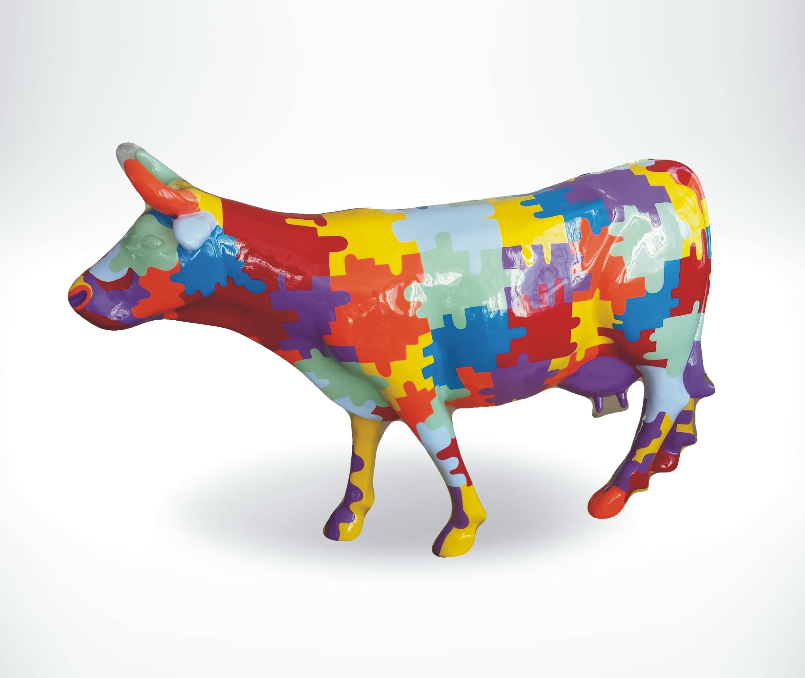 Fiberglass Cow Life Size Statue - Single Color 4 A cow statue painted with a colorful jigsaw puzzle pattern.
