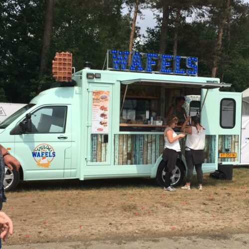 Light blue waffle food truck with a large waffle decoration and blue-lit