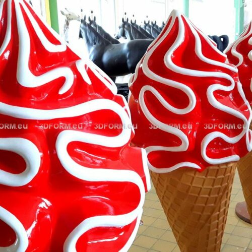 Large red and white ice cream cone sculptures in a row.