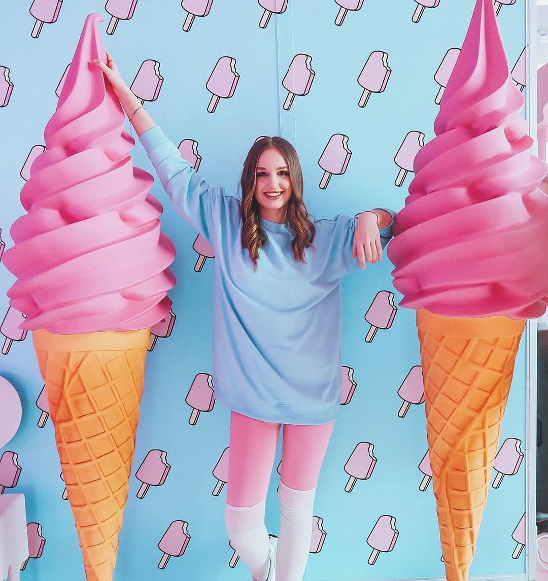 Advertising Soft Ice Cream Fiberglass Figure 1 Woman posing between two oversized pink ice cream cones with a blue and pink popsicle-themed background.