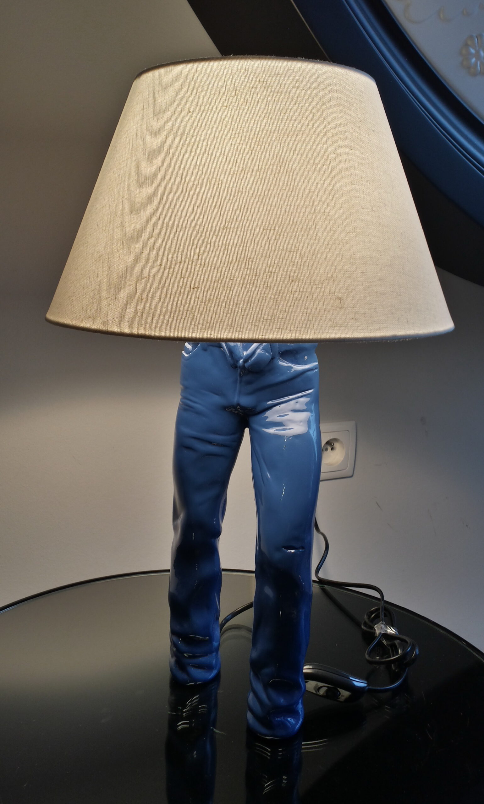 Small Decorative Jeans Resin Sculpture 2 Table lamp in the shape of human legs wearing blue pants with a beige lampshade.