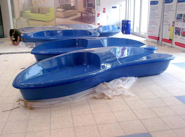 Shopping center fiberglass bench 3 Blue, canoe-shaped benches installed indoors on a tiled floor.
