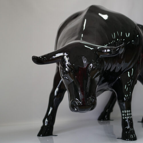 Glossy black sculpture of a bull with