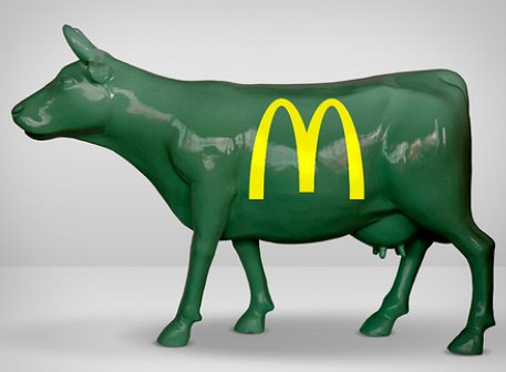 Fiberglass Cow Life Size Statue - Single Color 17 Green cow statue with the yellow McDonald’s logo on its side.