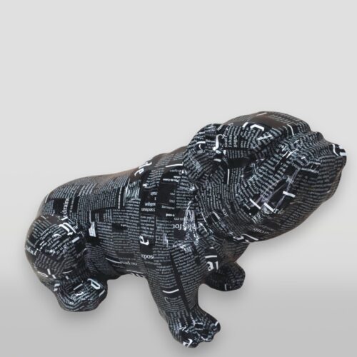 Metallic sculpture of a dog covered in black and white printed text.