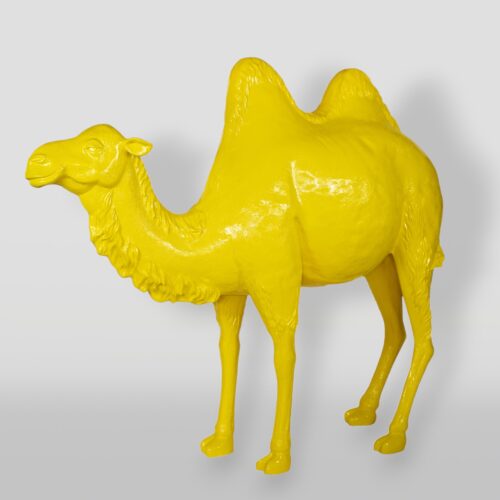 Bright yellow statue of a Bactrian camel with two humps against a plain white background.