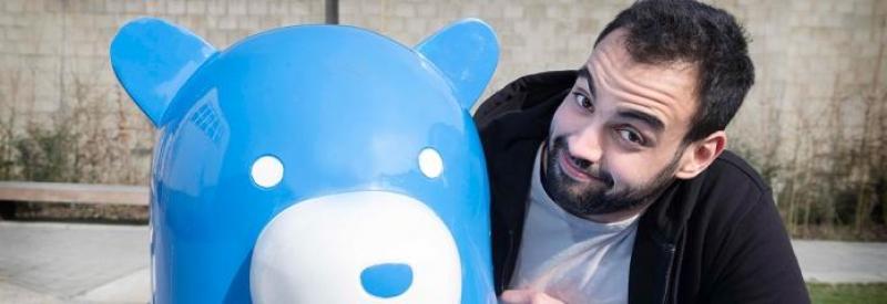 Bear on a Bench 3 Mężczyzna obok niebieskiego posągu misia.