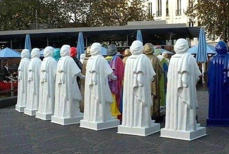 Replica of the Beethoven Monument 4 Ludzie przebrani za posągi w białych i niebieskich szatach w parku miejskim.