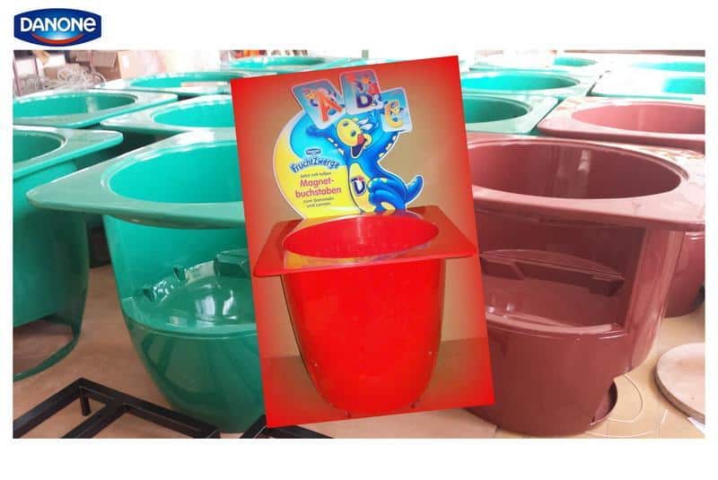 oryg_064490685_1129949550544944_1465385417682452480_o Green and brown plastic tubs with a red tub and a Danone brand label in the foreground.