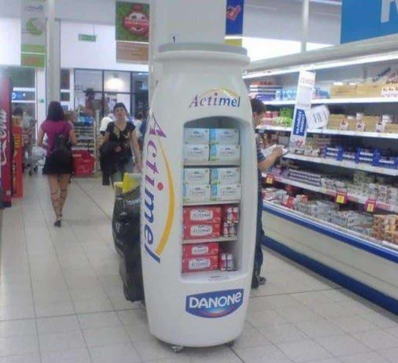 oryg_064490685_1129949550544944_1465385417682452480_o Actimel display shaped like a large bottle in a supermarket aisle.