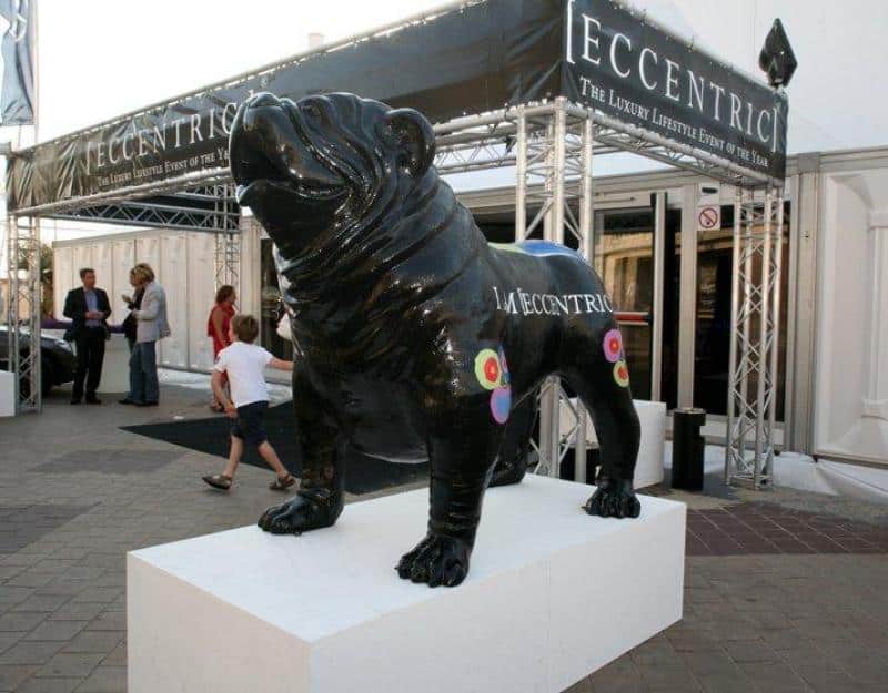 Large bulldog figure 4 Czarna rzeźba psa na białym postumencie przed wejściem na wydarzenie