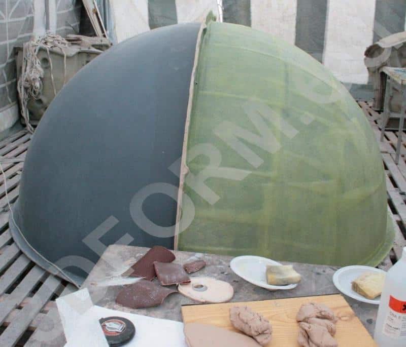 Giant Sphere in Urban Space 3 Półokrągła konstrukcja w dwóch kolorach, otoczona narzędziami rzemieślniczymi na drewnianej podłodze.