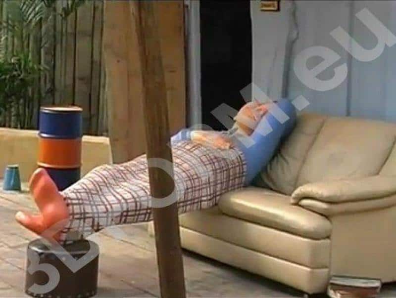 Figures for amusement park - Hugo Land 3 Mężczyzna leżący na kanapie na świeżym powietrzu, przykryty kocem, jego nogi podparte na beczce.