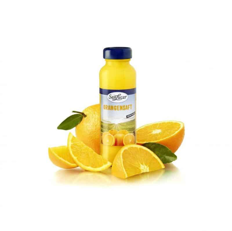 Juice Bottle 2 Butelka soku pomarańczowego SanLucar otoczona kawałkami pomarańczy.