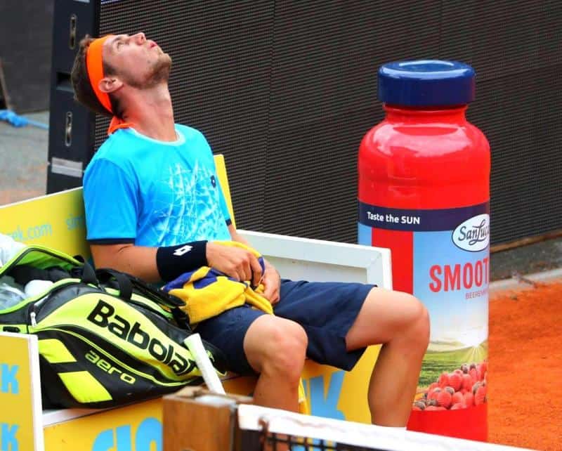 oryg_064490685_1129949550544944_1465385417682452480_o Tennis player sitting on a bench, leaning back with eyes closed, with a babolat bag beside him and a large smoothie bottle in the background.