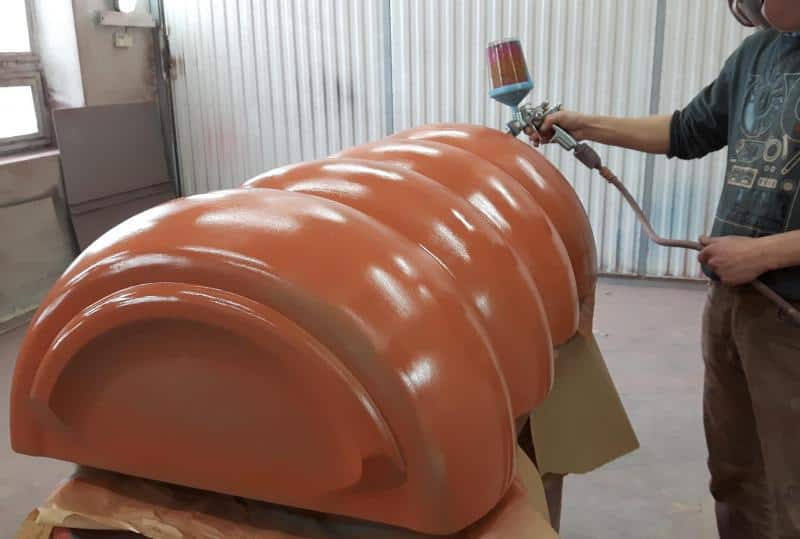 Mentos 3D billboard advertisement 3 Osoba malująca pistoletem natryskowym duży, pomarańczowy element.