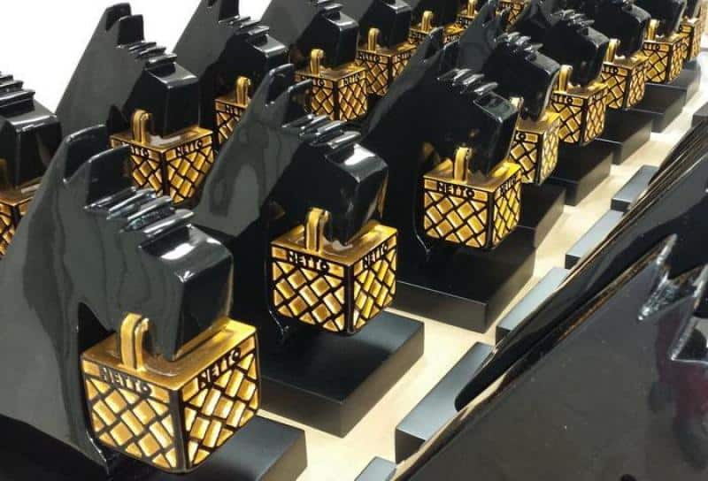 oryg_064490685_1129949550544944_1465385417682452480_o Rows of black dog-shaped statues holding gold latticed boxes with the word