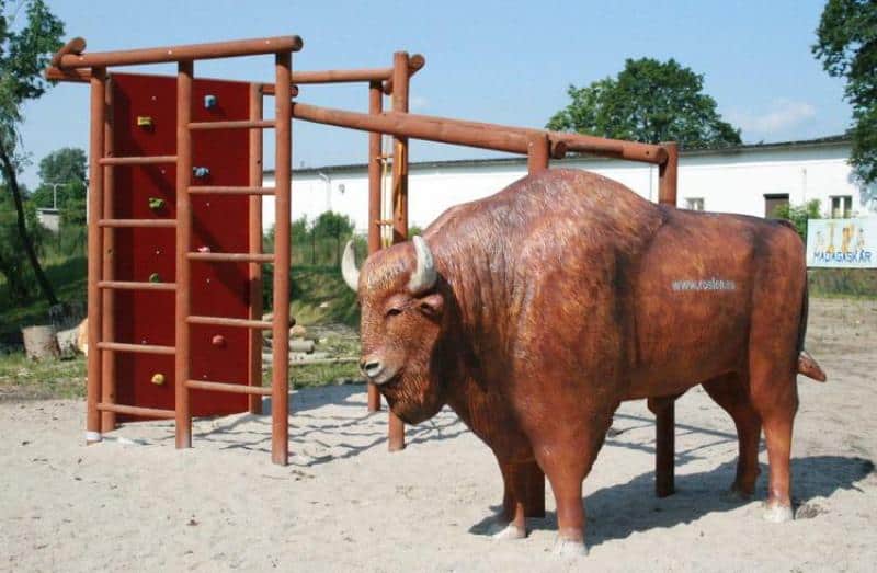 Figures in a theme park 6 Plac zabaw z dużą drewnianą konstrukcją i figurą żubra.