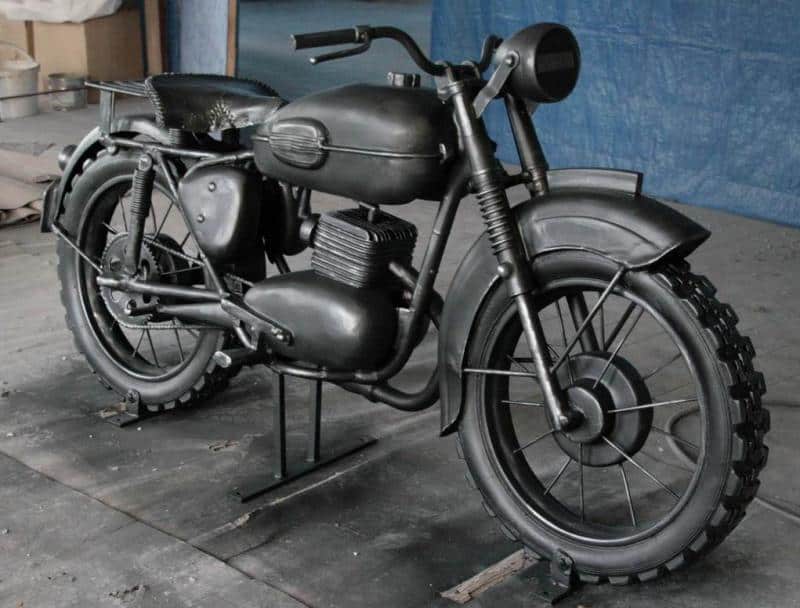 Iconic Motorcycle - Monument in Żagań 1 Czarny, zabytkowy motocykl na tle niebieskiej ściany.