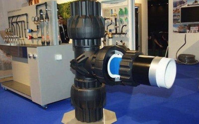 Tee - Pipe Fitting 1 Wystawa z dużą armaturą wodociągową w pomieszczeniu targowym.