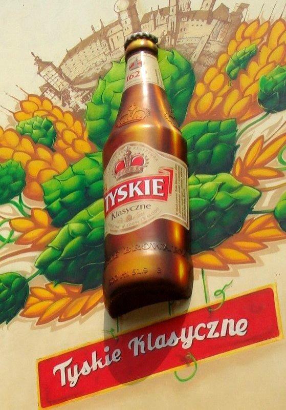 oryg_064490685_1129949550544944_1465385417682452480_o Bottle of Tyskie Klasyczne beer displayed against a colorful background featuring illustrations of hops and grains with text reading