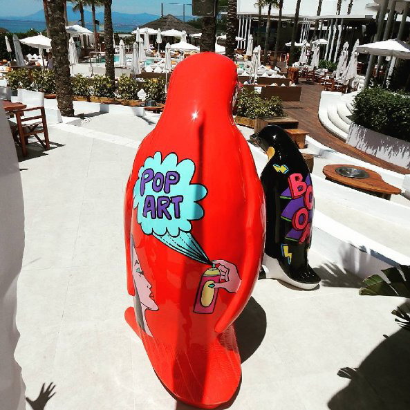 Large Fiberglass Penguin Statue - Natural Colors. 1 Two penguin sculptures painted in a pop art style, one red with