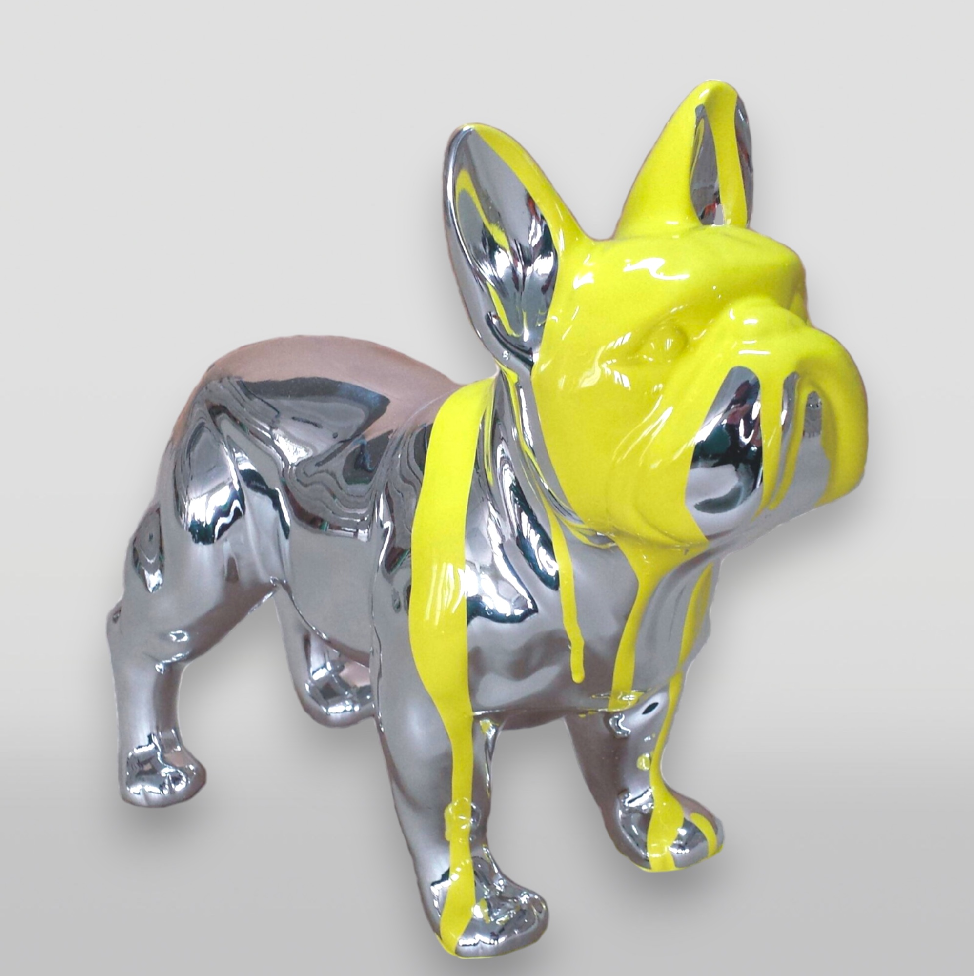 Small Standing Resin Bulldog Figurine - Chrome and Paint Edition 1 A chrome bulldog statue with yellow paint dripping over its head and body.