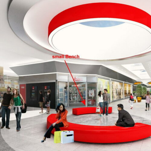 Modern indoor shopping mall with a large circular red bench and several people walking or sitting.
