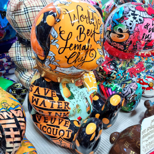 Colorful decorative bear sculptures with various graffiti-style designs and inscriptions, including 