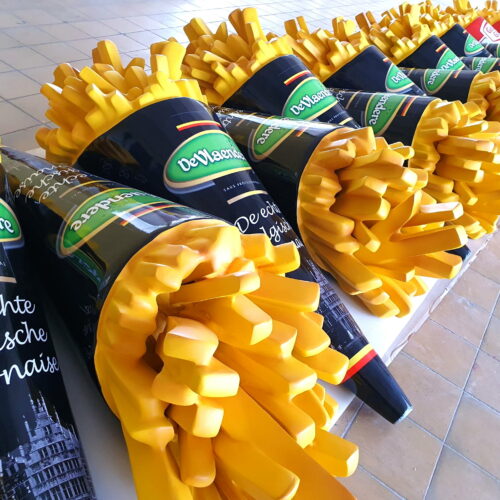Large plastic models of French fries in black and green cones labeled 