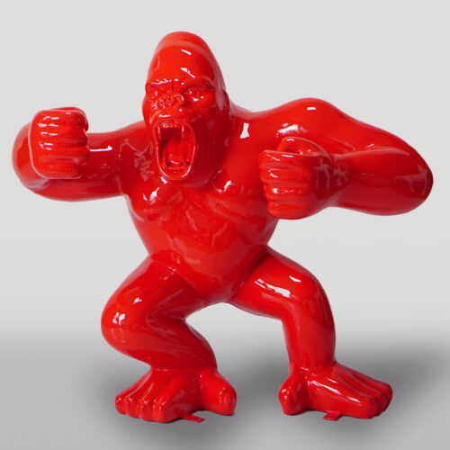 Red sculpture of an angry gorilla with clenched fists, standing in an aggressive pose.