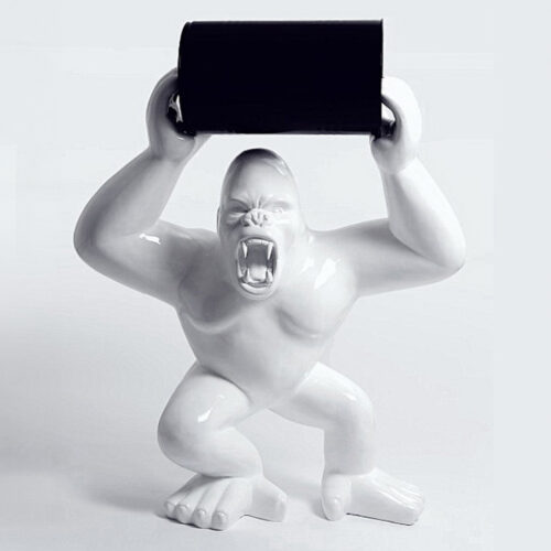 A ceramic gorilla figurine with an open mouth, holding a horizontal black cylinder above its head.