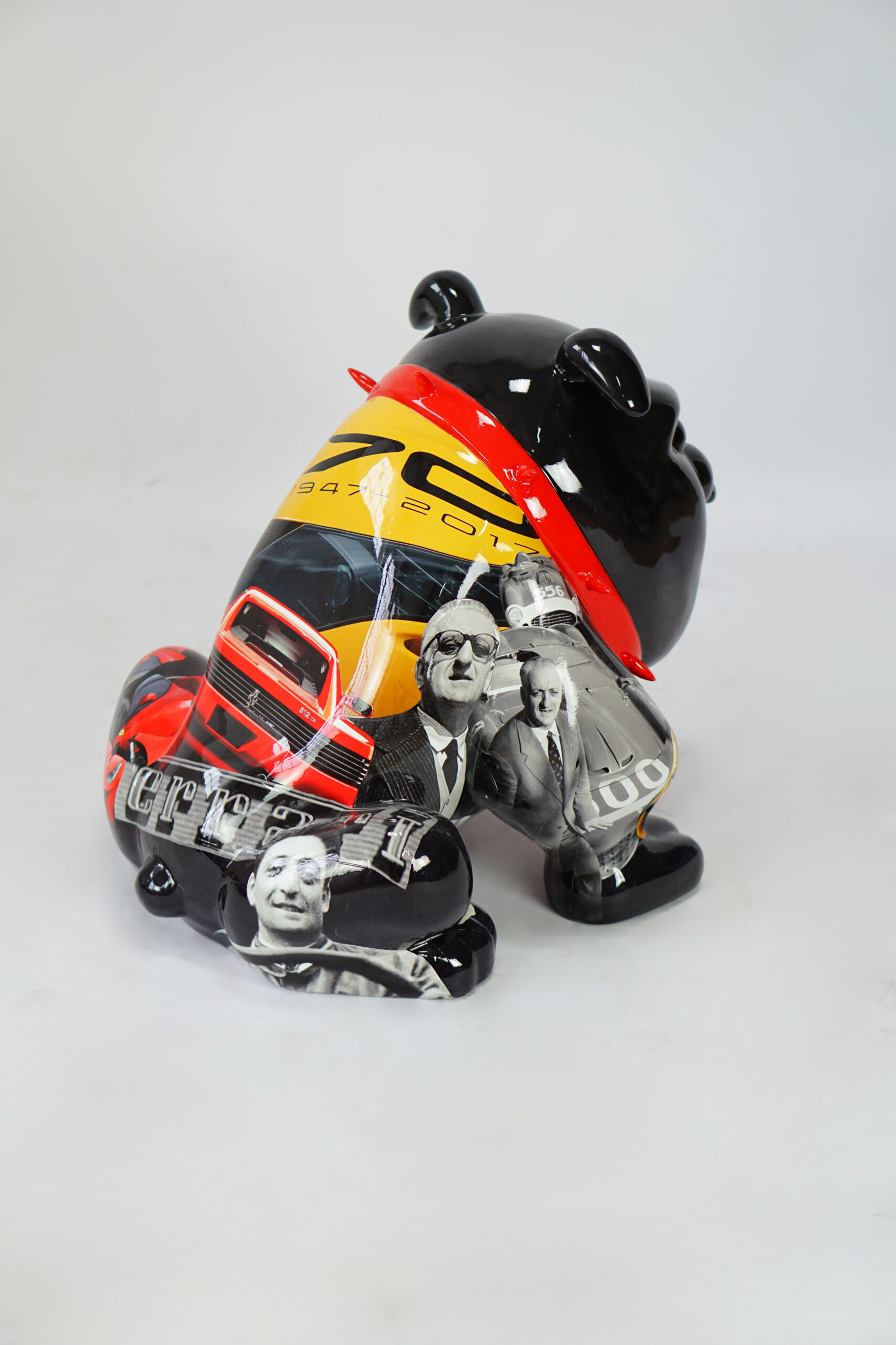 Bulldog Avella 55cm dog - Ferrari 3 A black statue of a stylized panda bear decorated with images of classic cars and historical figures, featuring a Ferrari 70th anniversary theme (1947-2017).