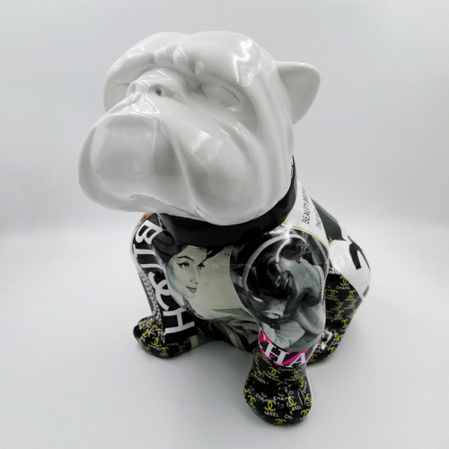 Ceramic bulldog figurine with a white head and body covered in black and white vintage magazine images and designer logos.