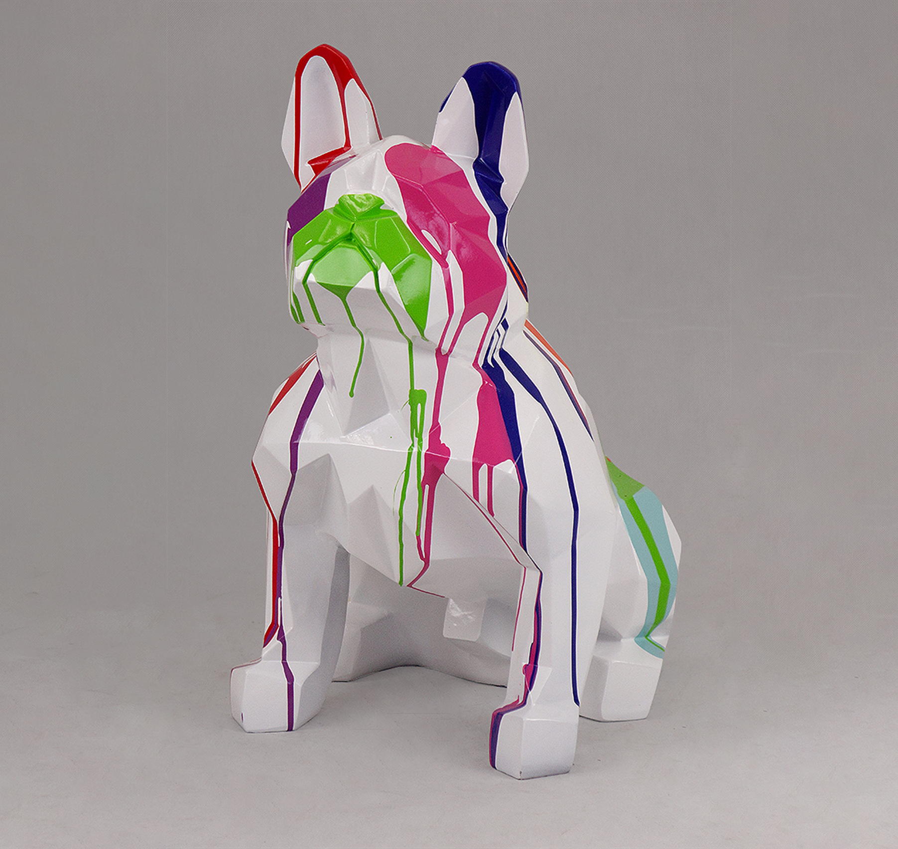 Sitting Bulldog Square Dog - White Trash 1 A white sculpture of a French Bulldog with colorful paint drips in red, green, blue, pink, and purple.