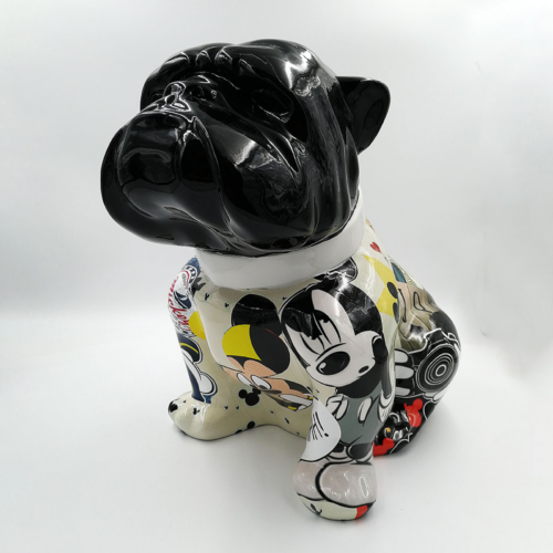Ceramic bulldog figurine with a black head and a body covered in colorful cartoon illustrations.