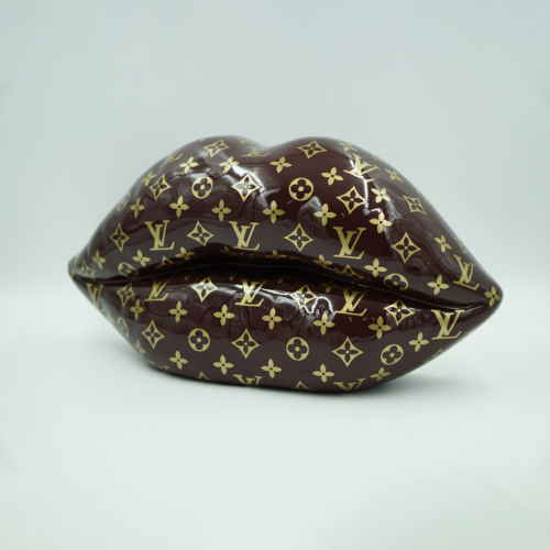 Sculpture of lips covered in a brown and gold Louis Vuitton monogram pattern.