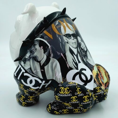 White bulldog figurine with spiked collar and collage of black and white magazine images, featuring logos and photos from Vogue and Chanel.