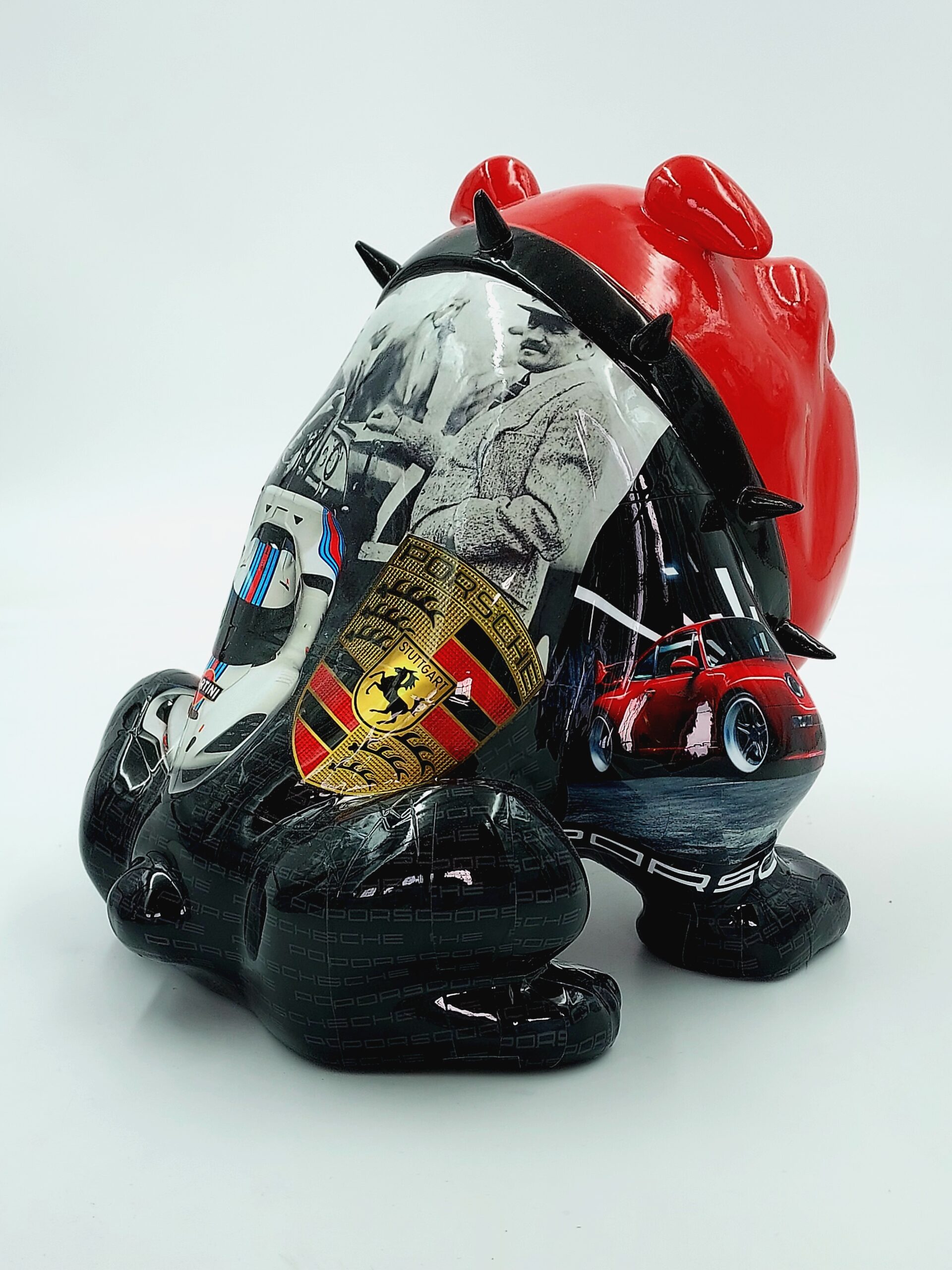 Bulldog Avella 55cm dog - Porsche 3 Decorative sculpture of a bulldog with a red head featuring car-related images, including vintage photos, a Porsche logo, and a red sports car on a black background.