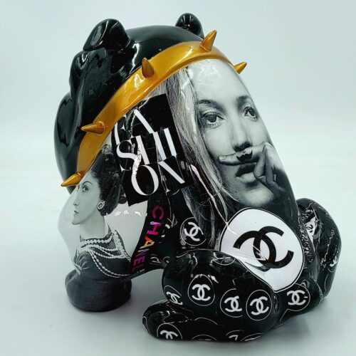 Black sculpture of a bear adorned with fashion magazine cutouts, gold spikes, and Chanel logos.