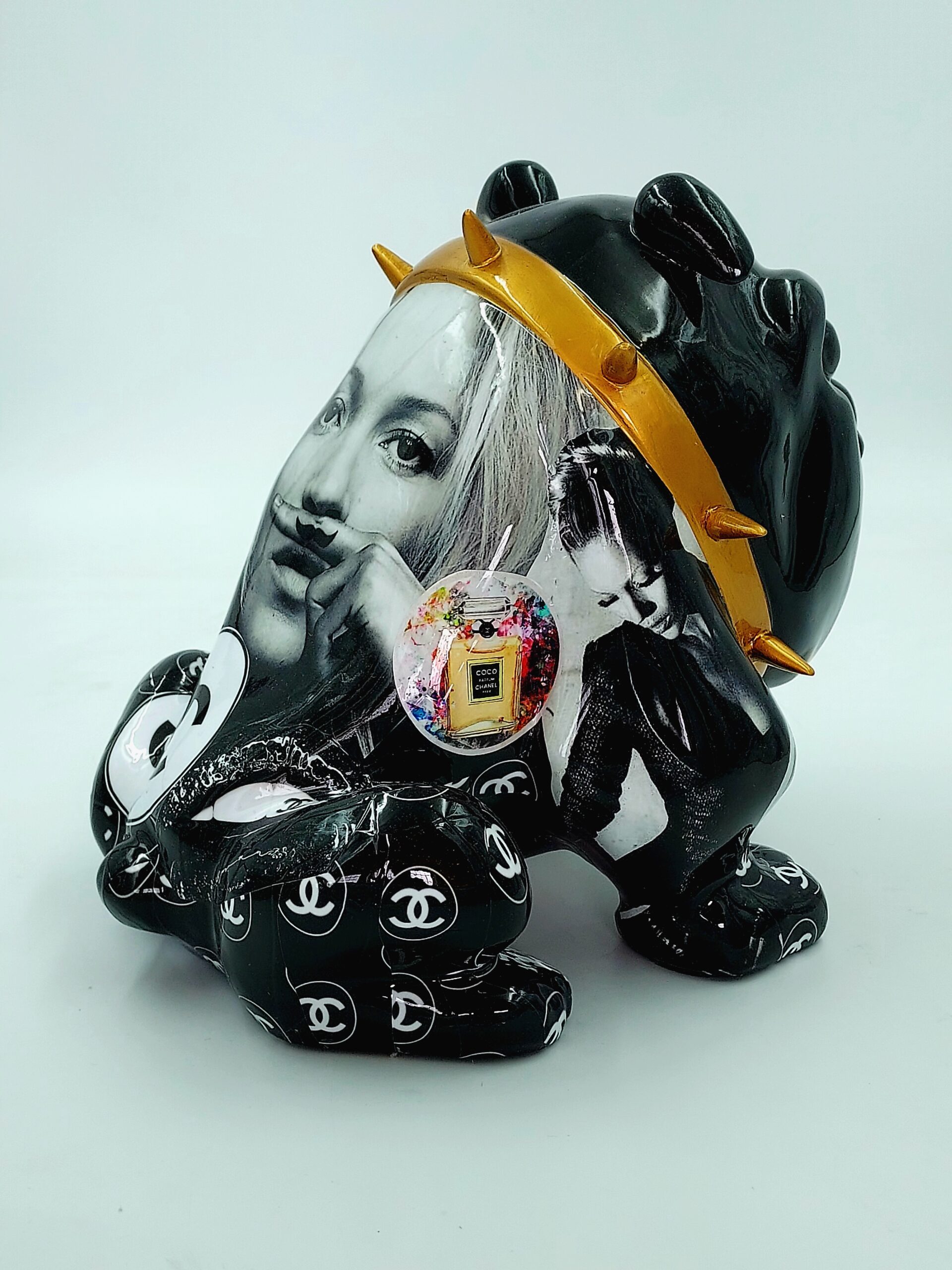 Bulldog Avella 55cm dog - Coco 3 Black ceramic sculpture featuring a lion adorned with black-and-white images of women, a gold spiked crown, Chanel logos, and a small embedded Chanel perfume bottle.