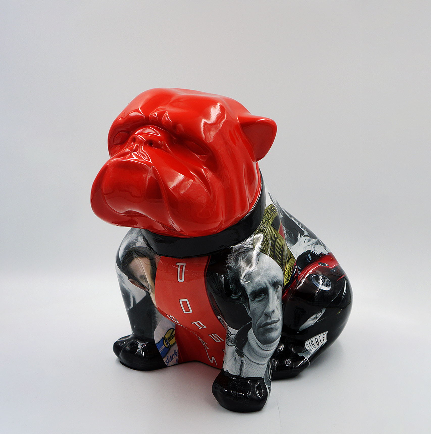 Bulldog Angelo 40cm dog - Porsche 1 Statue of a bulldog with a glossy red face and a black body decorated with various graphic images and text.