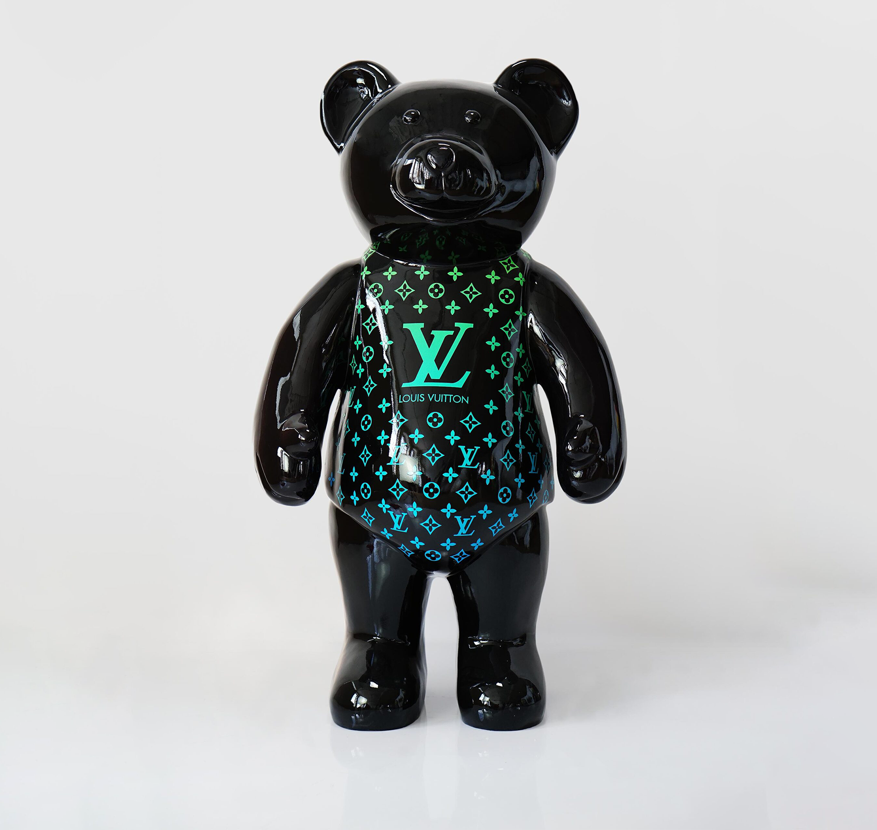 Teddy bear standing monogram - green gradient 1 Black glossy bear figurine with Louis Vuitton branding and monogram pattern in green and blue.