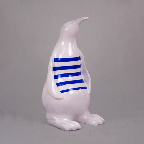 White penguin sculpture with blue horizontal stripes on its torso.