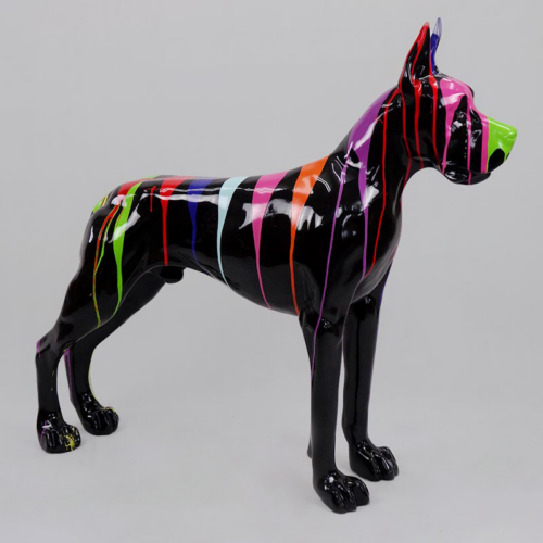 A glossy black dog sculpture with multicolored paint drips covering its surface.
