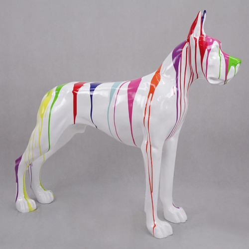 Sculpture of a dog painted white with colorful drips of paint, featuring shades of green, red, blue, yellow, pink, and orange.