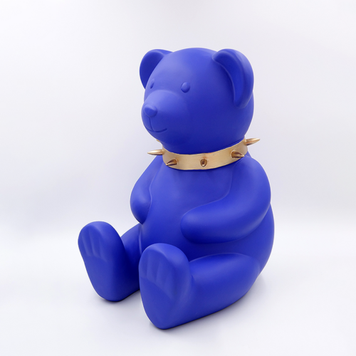 Blue bear figure wearing a gold spiked collar.