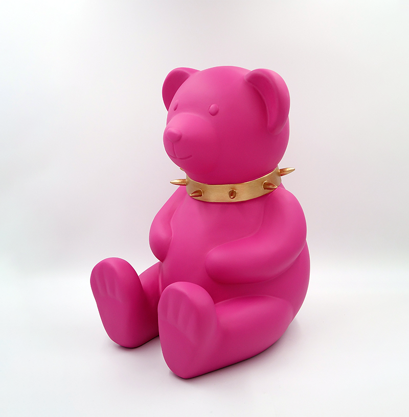 Bear H-45 cm - pink matte 1 Pink teddy bear figurine wearing a gold spiked collar, sitting upright against a white background.