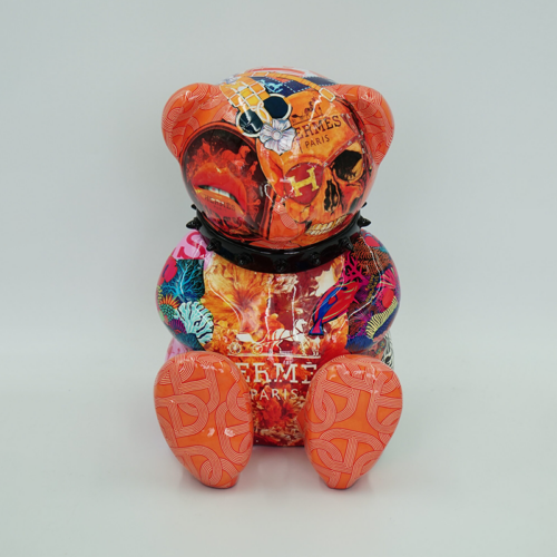 Colorful teddy bear figurine with a mixed collage of patterns, skull graphics, and text, featuring the word